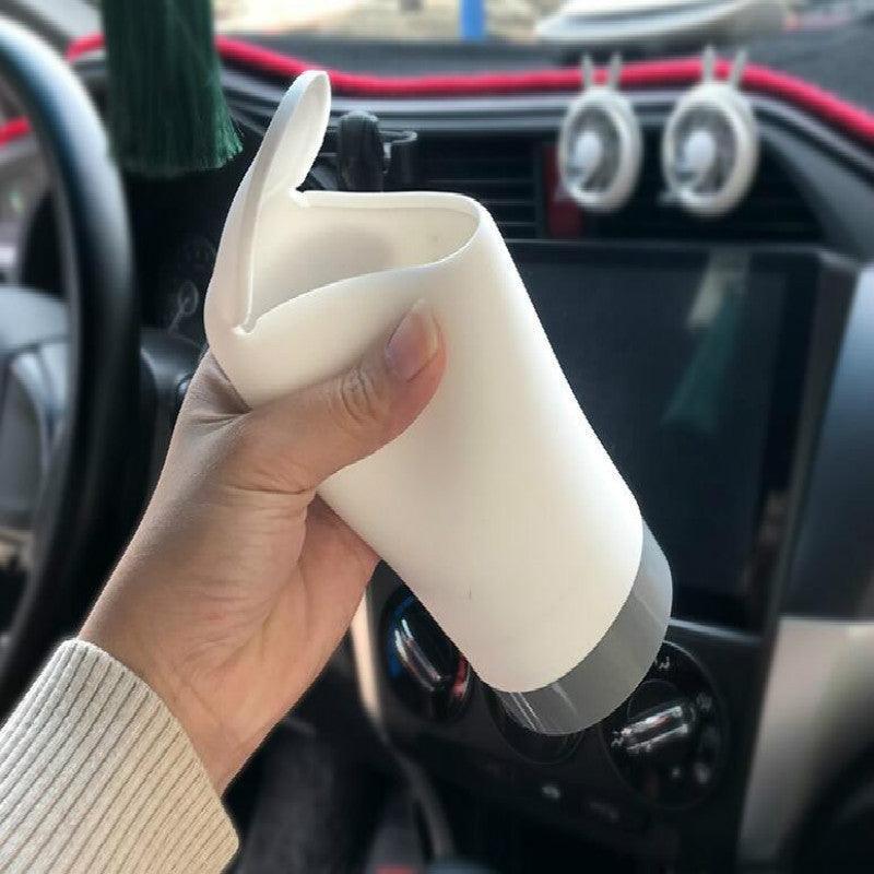 Hand squeezing the soft silicone body of the mini car trash can